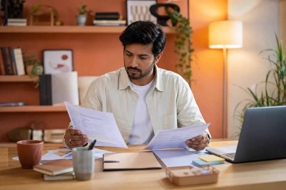 Indian job seeker organizing resume and job description before a mock interview